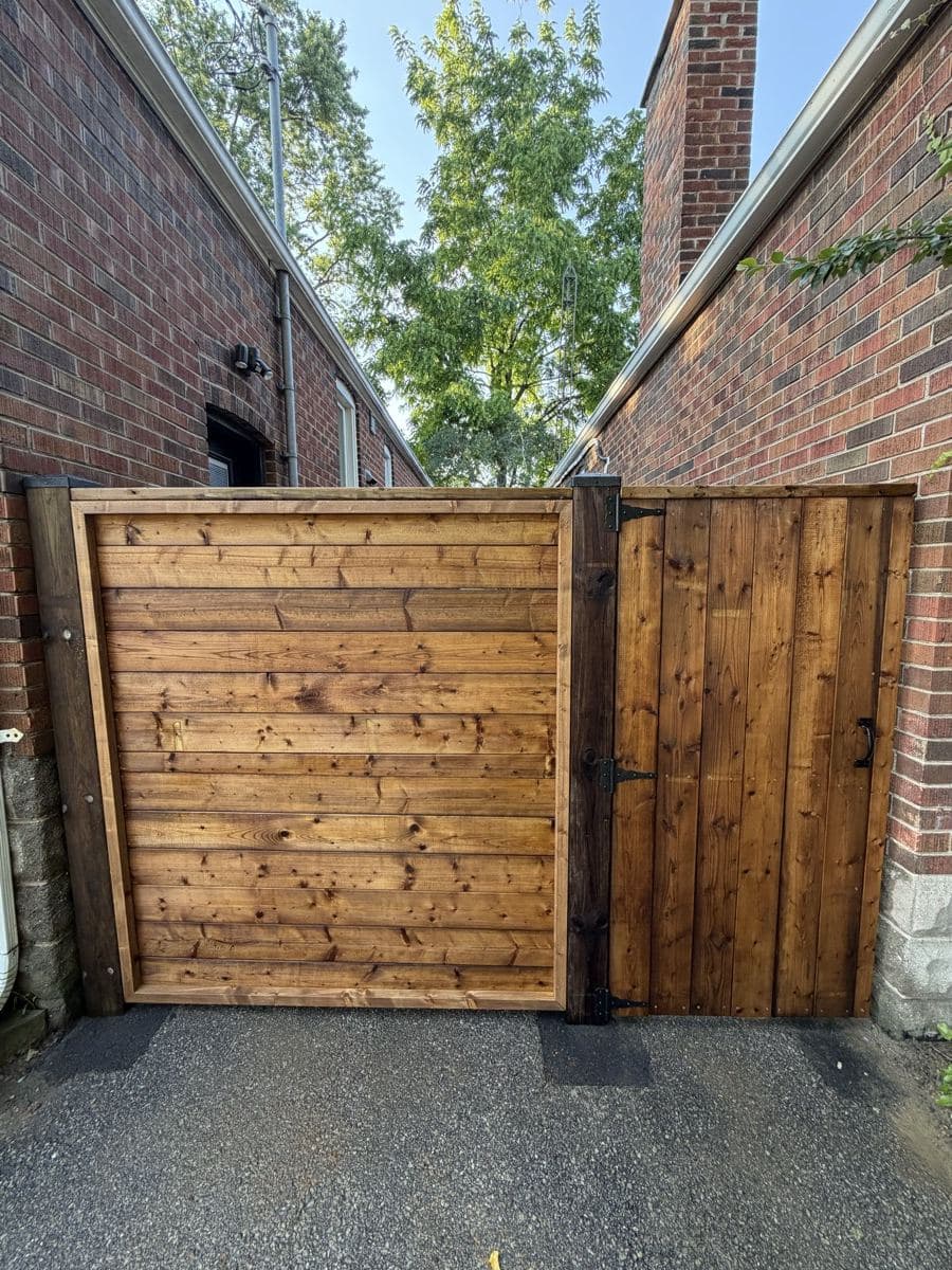 A custom wood privacy fence and gate installed by HB Landscaping